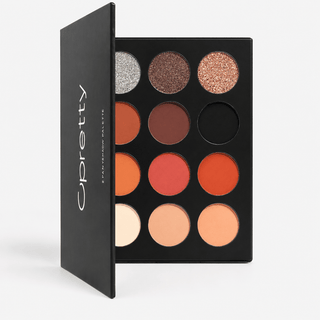 An open eyeshadow palette by Upretty, showing 12 circular pans in warm neutrals, oranges, reds, and shimmers, with the black outer cover visible on the left.